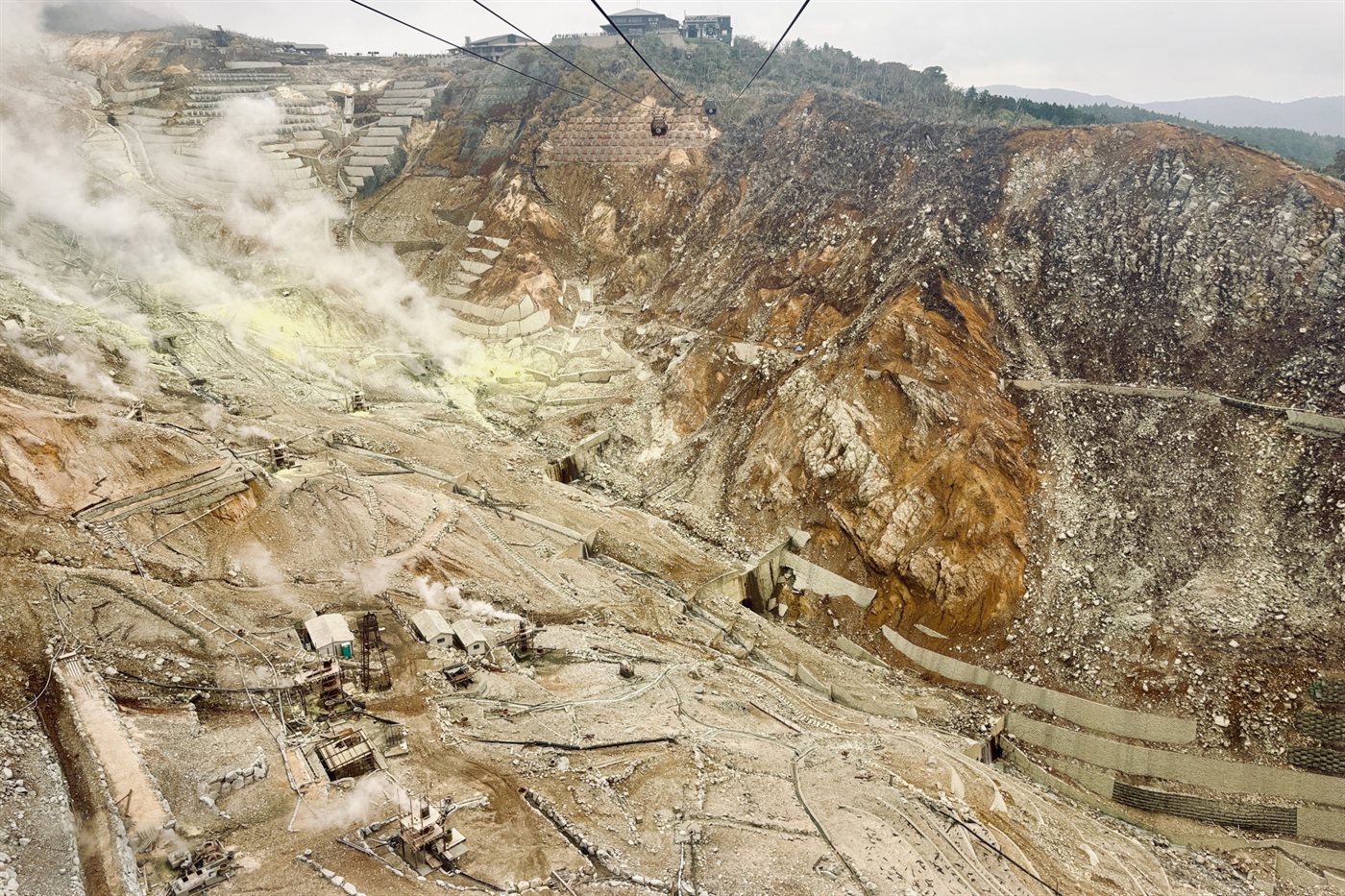 Steam rising from the Owakudani volcanic valley with a ropeway cabin above